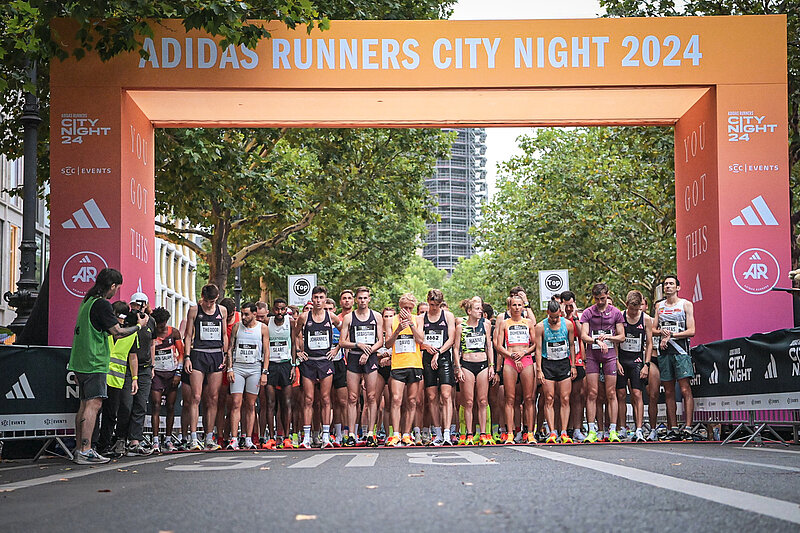 Participants behind the starting line shortly before the start of the adidas Runners City Night