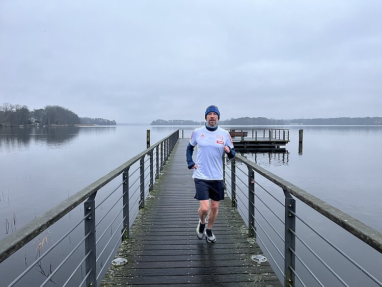Berlin New Year's Eve run: Man trains in the cold and runs along a footbridge towards the shore © SCC EVENTS
