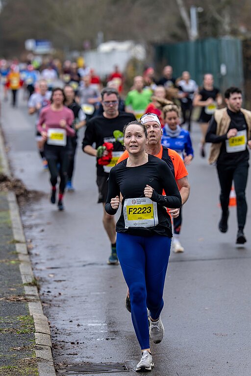 Berliner Silvesterlauf 2022: Gruppe von Läufer:innen legt angestrengt die letzten Meter zurück @ SCC EVENTS / Tilo Wiedensohler