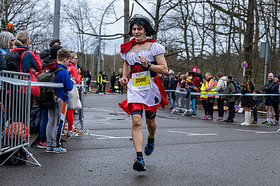 Berlin New Year's Eve Run 2022: Costumed runner passes spectators in the finish lane @ SCC EVENTS / Tilo Wiedensohler